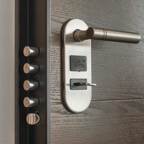 Metal door handle and lock system with key inserted, showcasing security features.